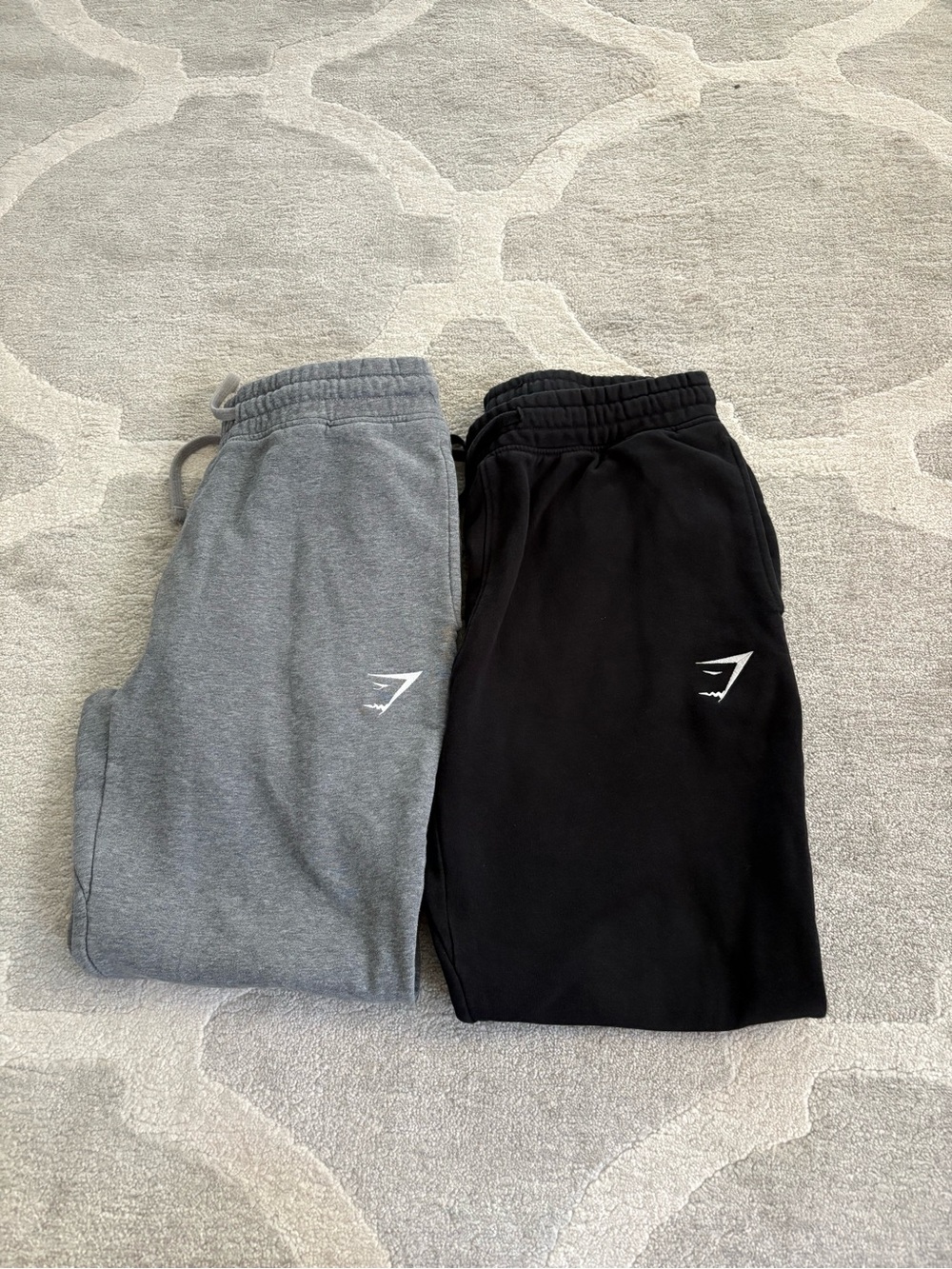 Two pairs of men Gymshark fleece joggers in Black and Grey